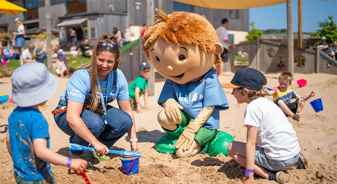 William and children play in sandpit