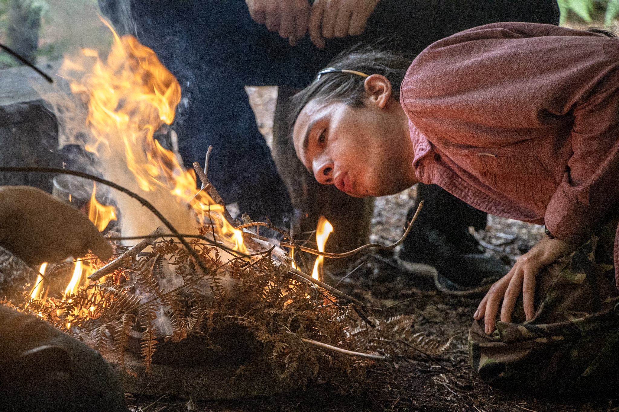 A man taking part in a team building bushcraft exercise at New Forest Activities