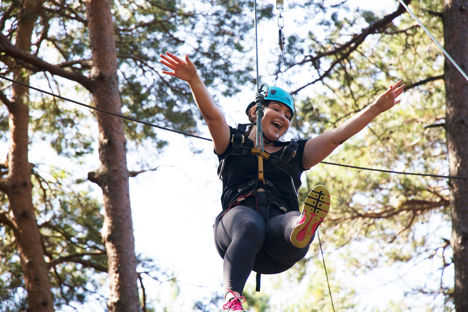 A woman taking part in high ropes after a back to business coaching workshop