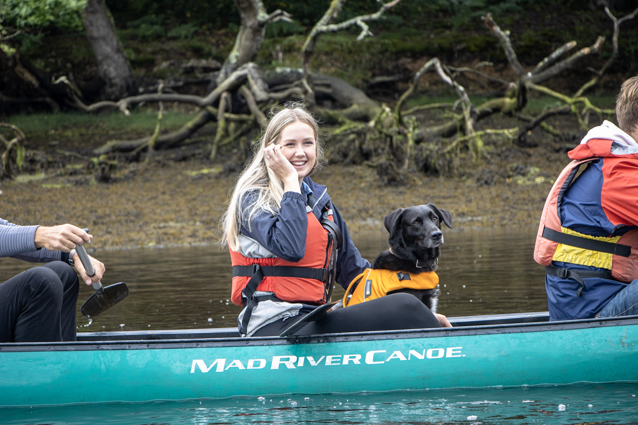 Lady with dog in a canadian-style canoe. 
