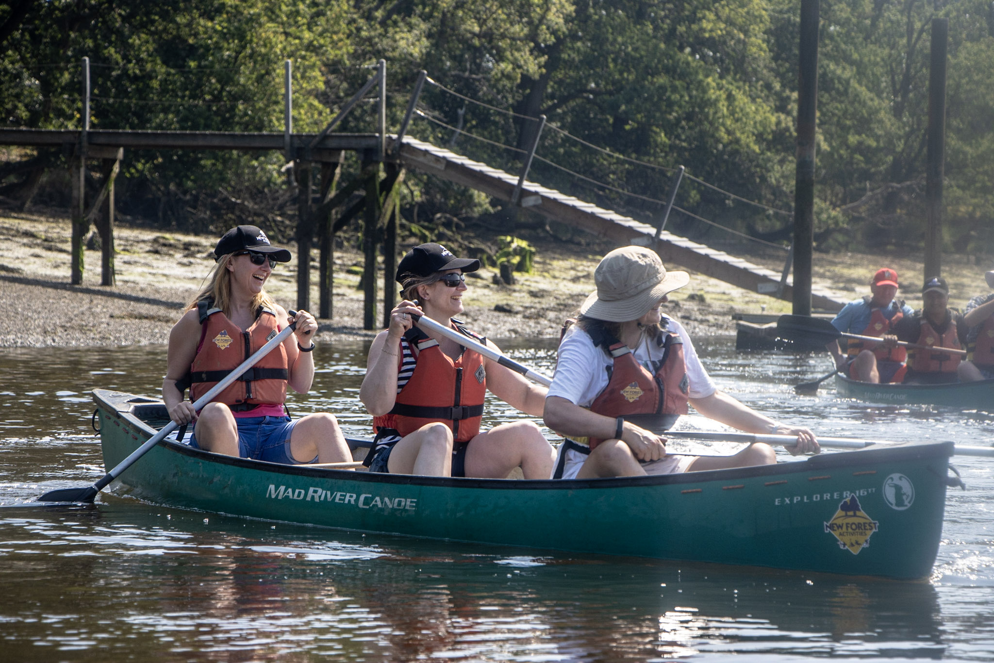 A group of colleagues enjoying a canoeing team building event on the Beaulieu River