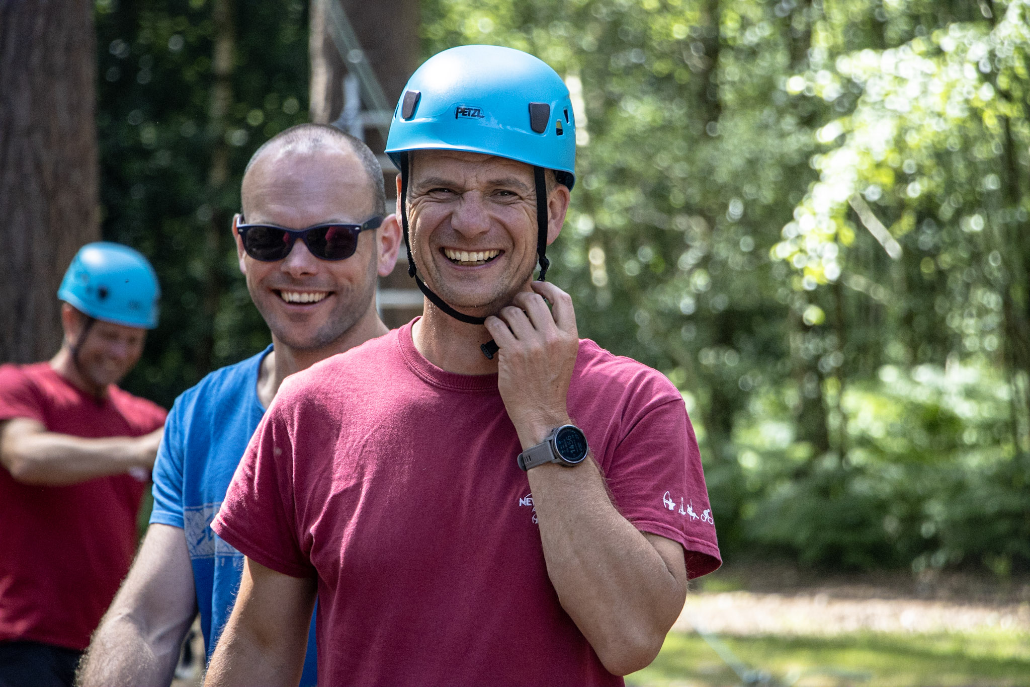 An Outdoor instructor smiling whilst delivering a high ropes session