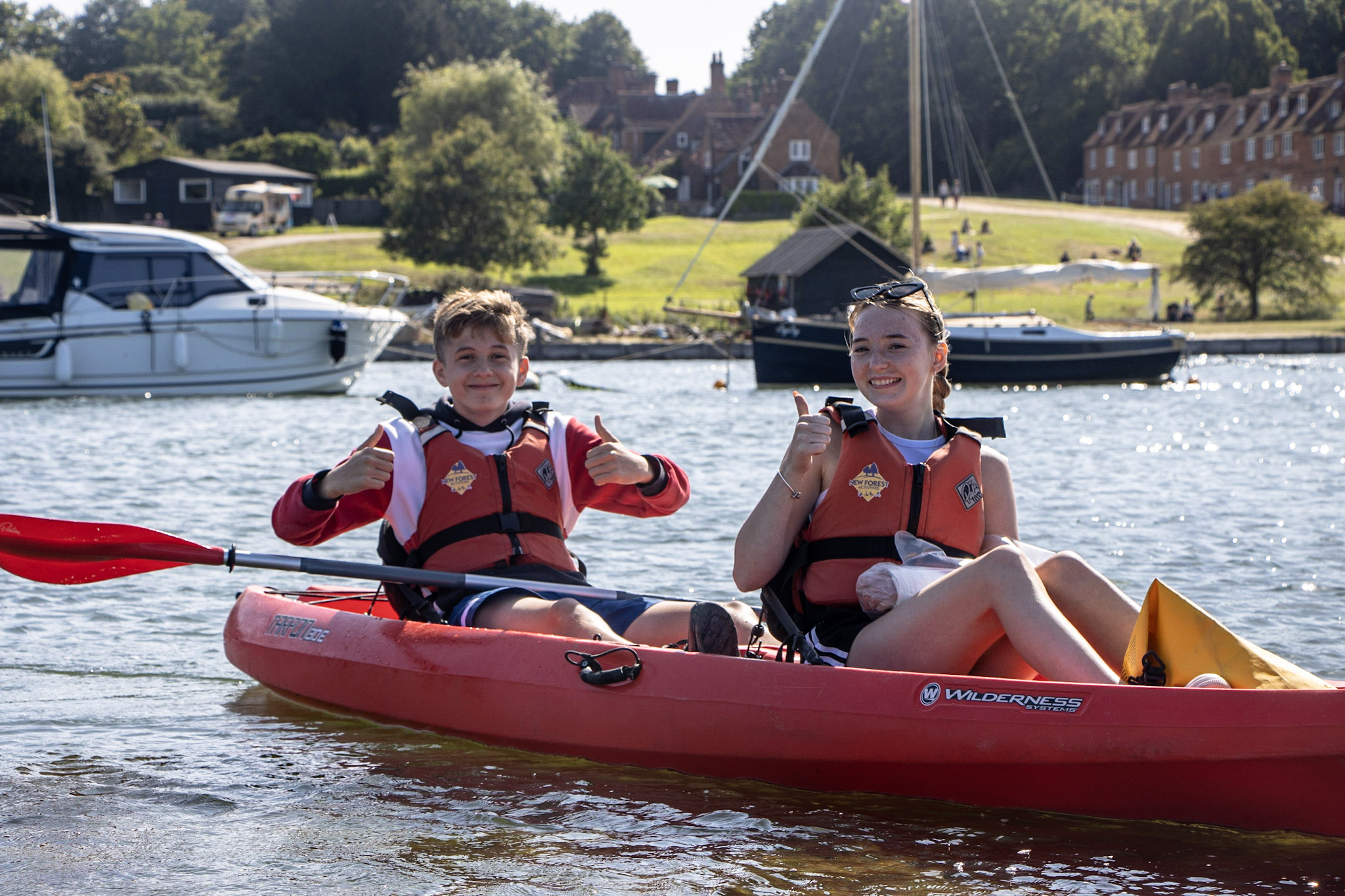 Two students enjoying kayaking on the Beaulieu River as part of a school trip in The New Forest