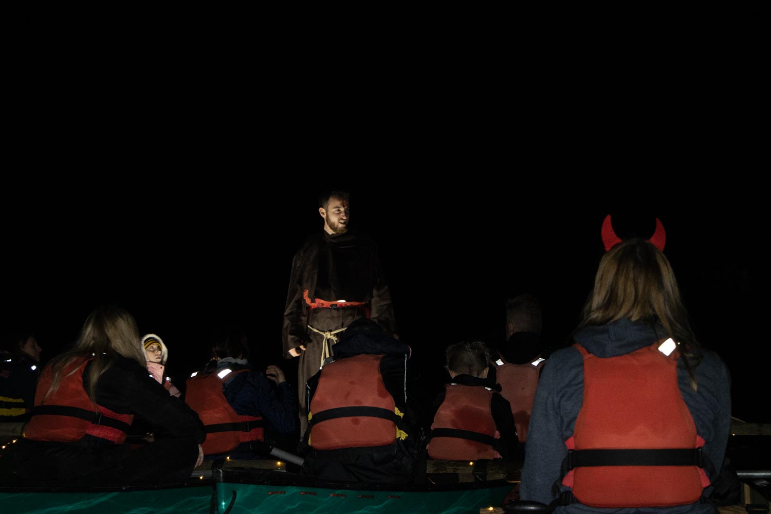 A group listening to the monk on their Spooky Halloween River Tour.