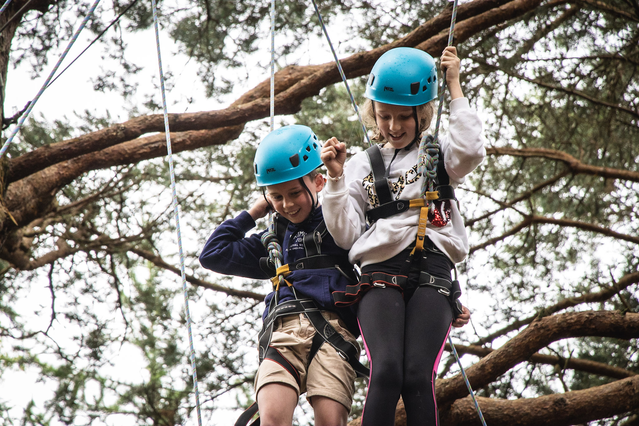 Two students enjoying the high ropes on a school residential trip with New Forest Activities
