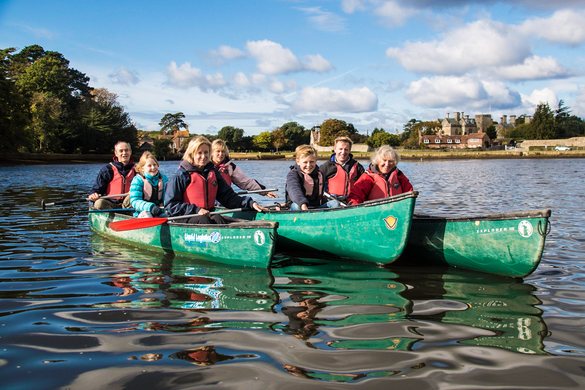 Family and friends enjoying a group canoeing adventure in autumn