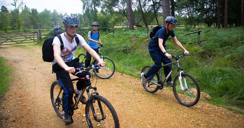 A group of young cyclists setting off on a New Forest bike hire trail from Beaulieu