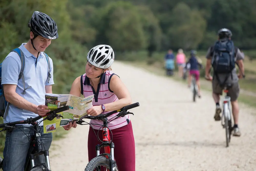 A couple checking their trail map on a New Forest cycle hire route