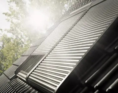 Anti-heat and anti-sound shutters on velux roof windows on a sunny day.
