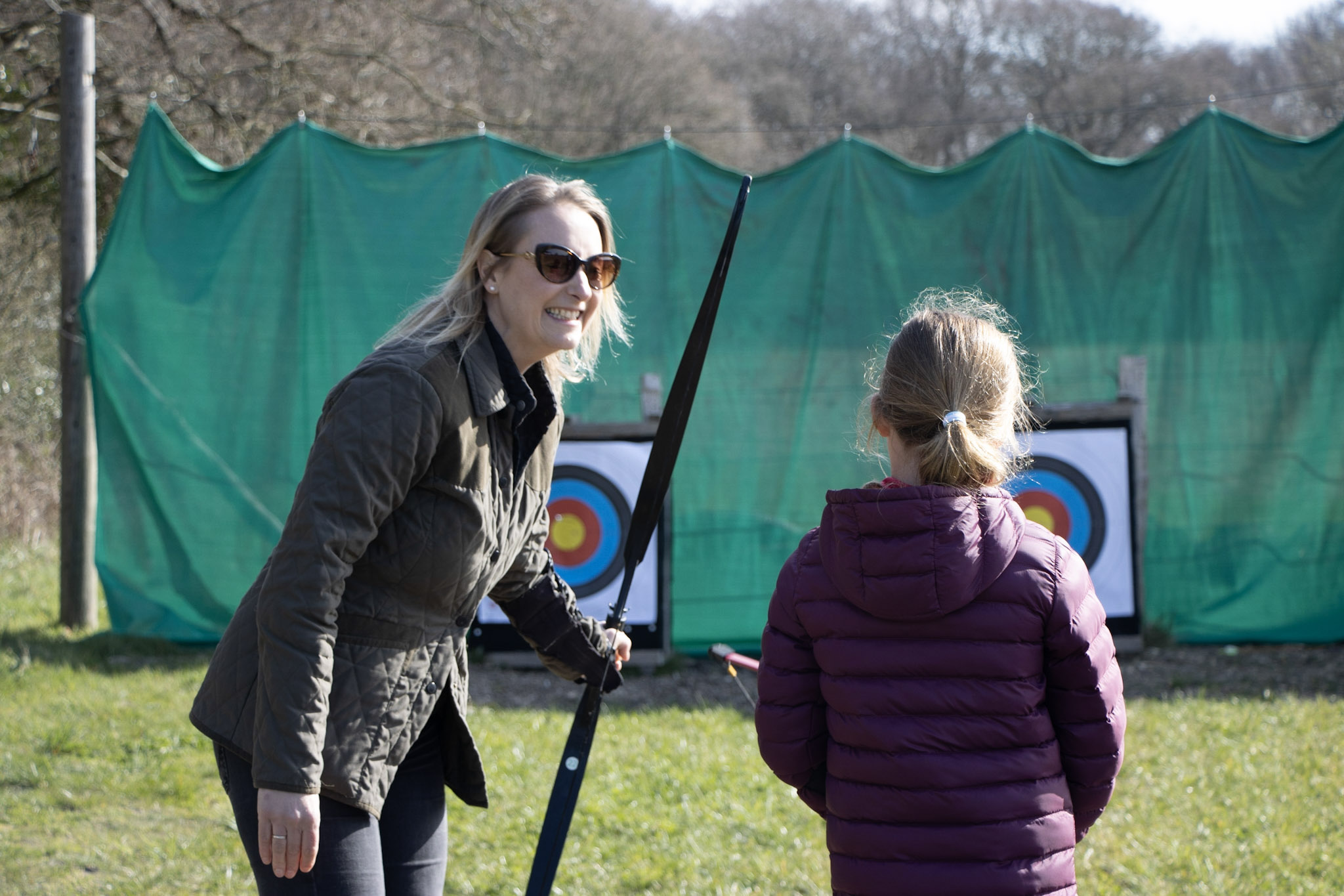 A mother and daughter taking part in archery