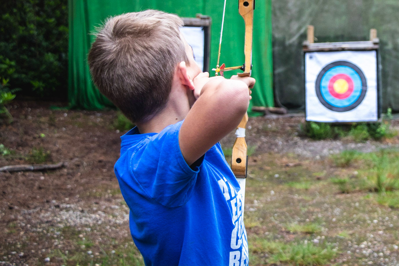 A boy taking part in archery during a family day out with Cairngorms Activities