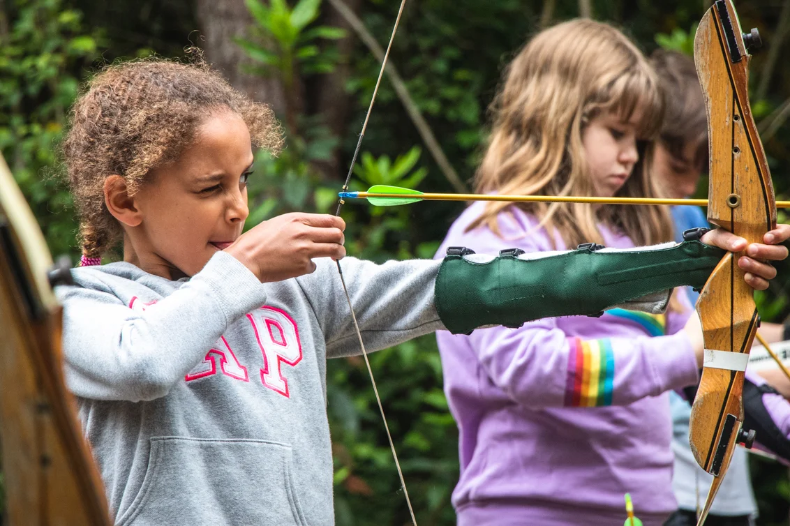A youth group taking part in archery during a residential programme