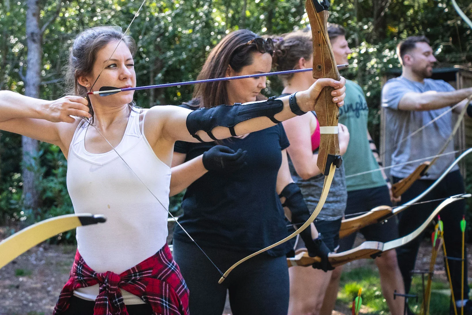 A corporate group taking part in archery during a land-based half-day option