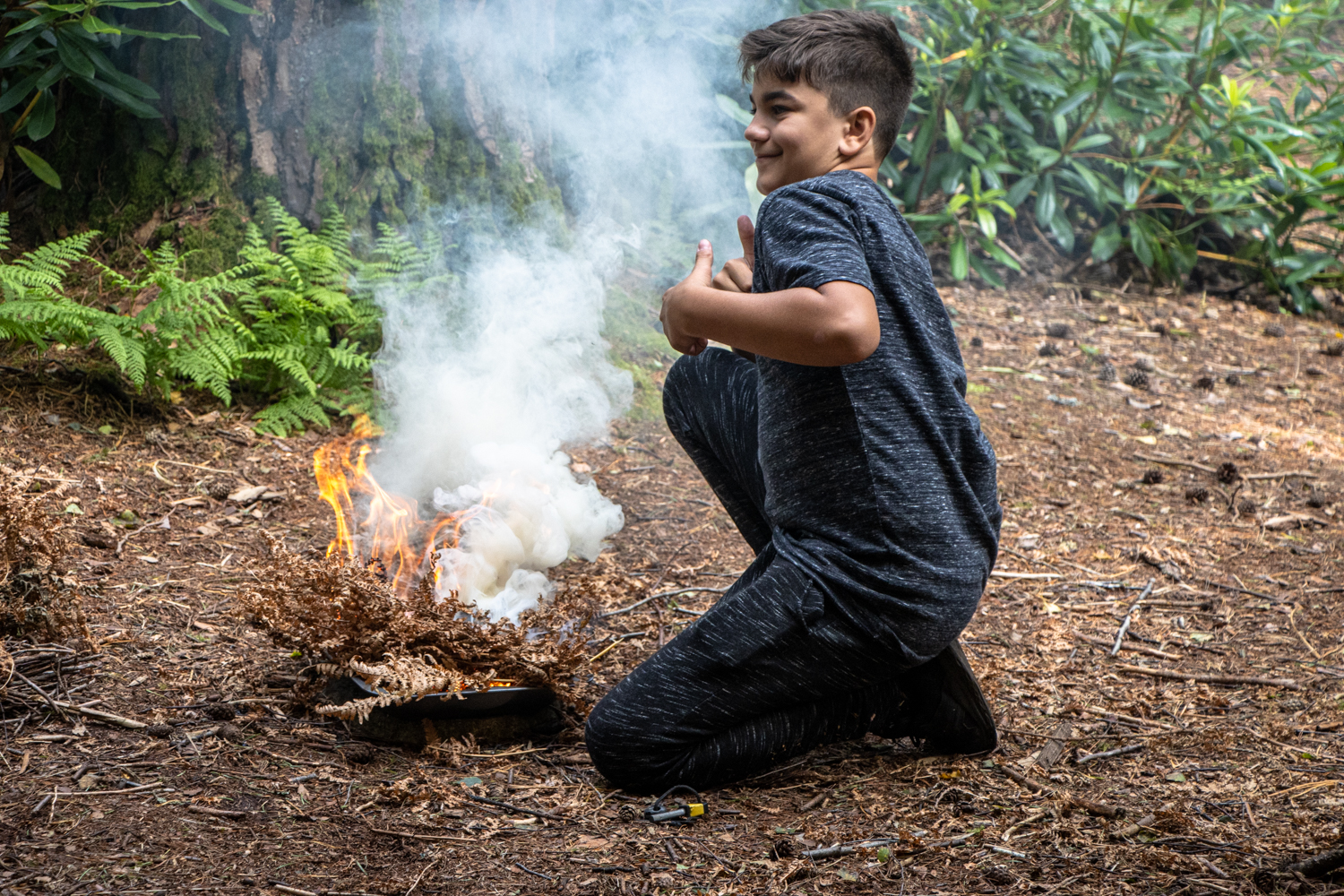A boy learning to light fires during a bushcraft party