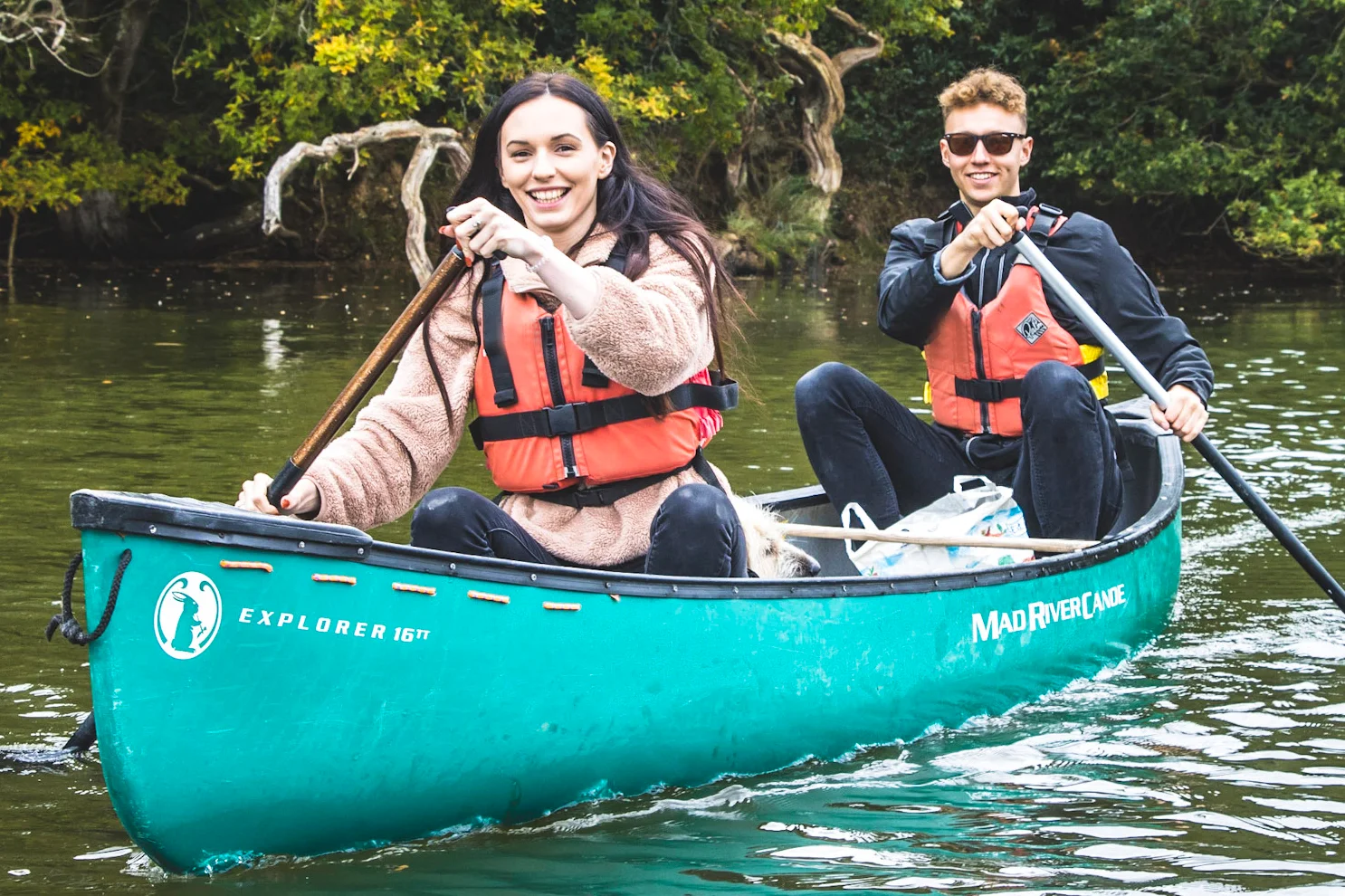 A couple enjoying a paddle in a canoe during the winter