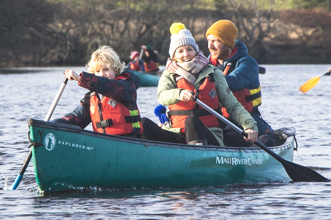 A family paddling on the River Spey during the winter