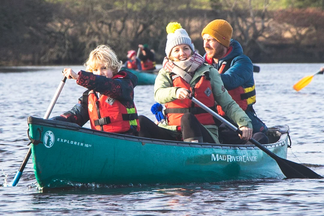 A family paddling on the River Spey during the winter