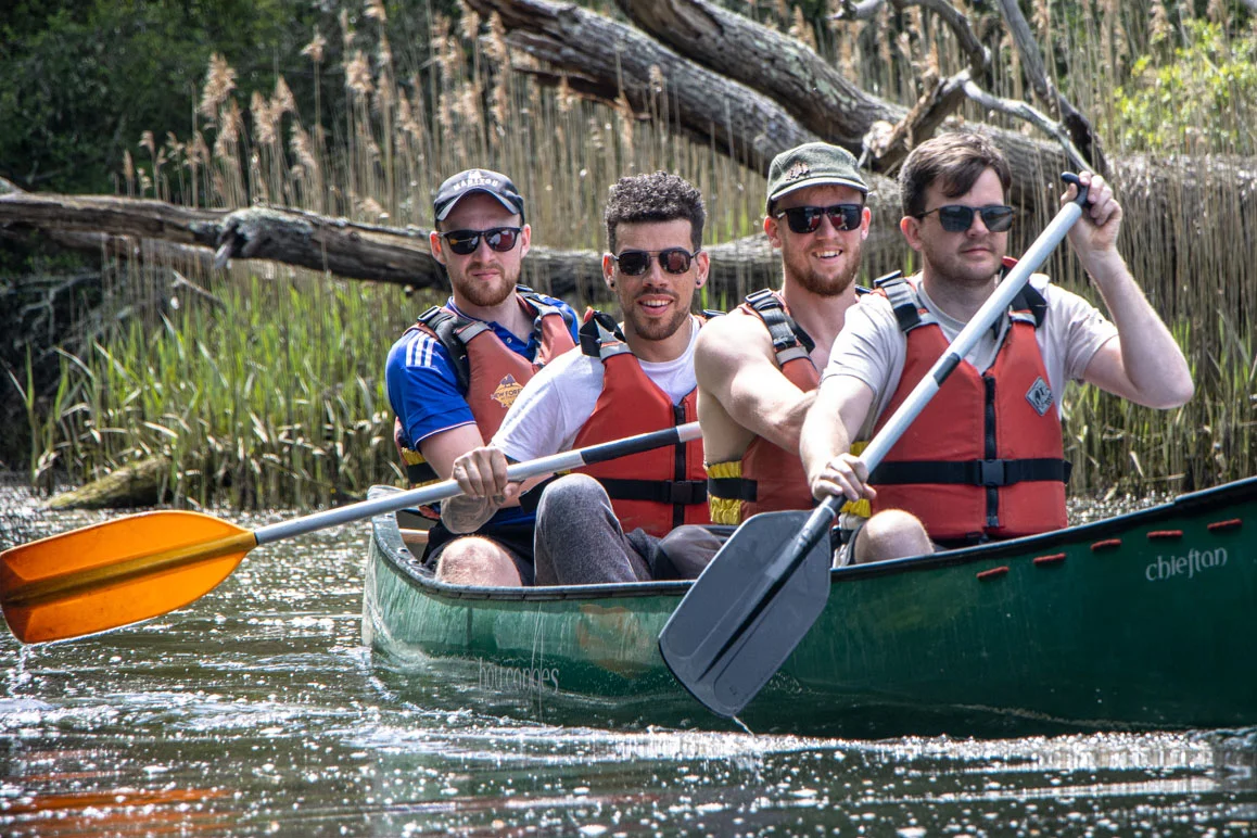 A group of friends canoeing on the River Spey