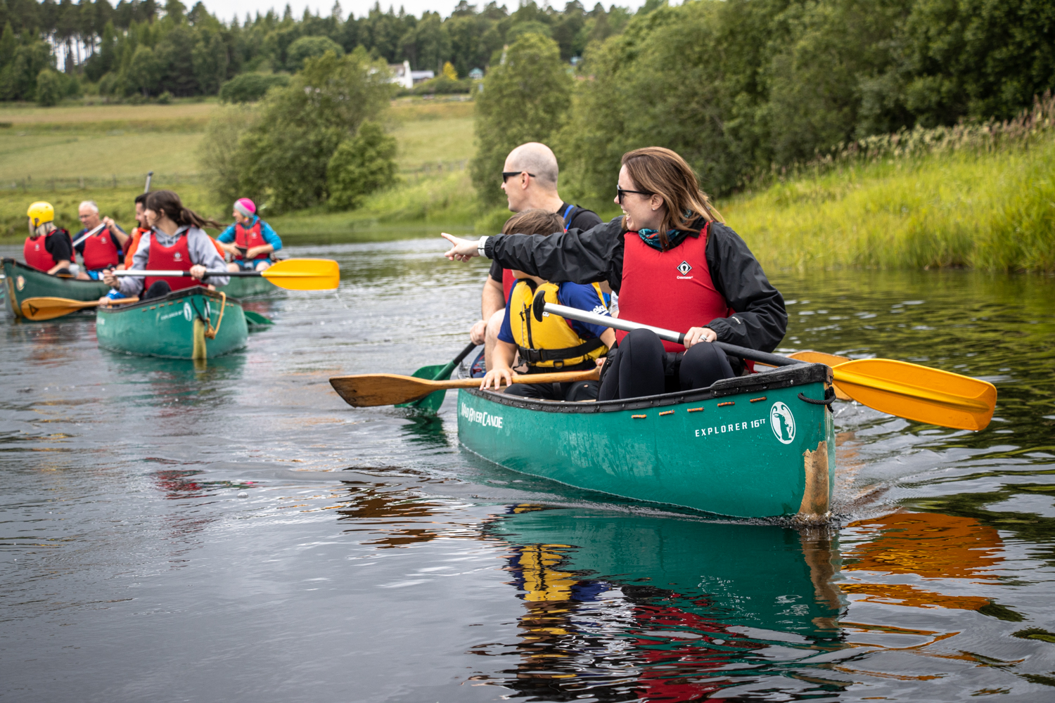 A family enjoying a guided canoeing tour on the River Spey