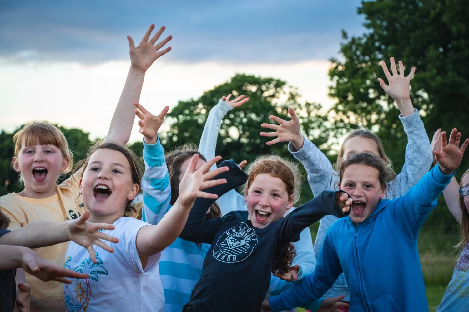 A group of girls enjoying songs around the campfire on a residential trip with Cairngorms Activities