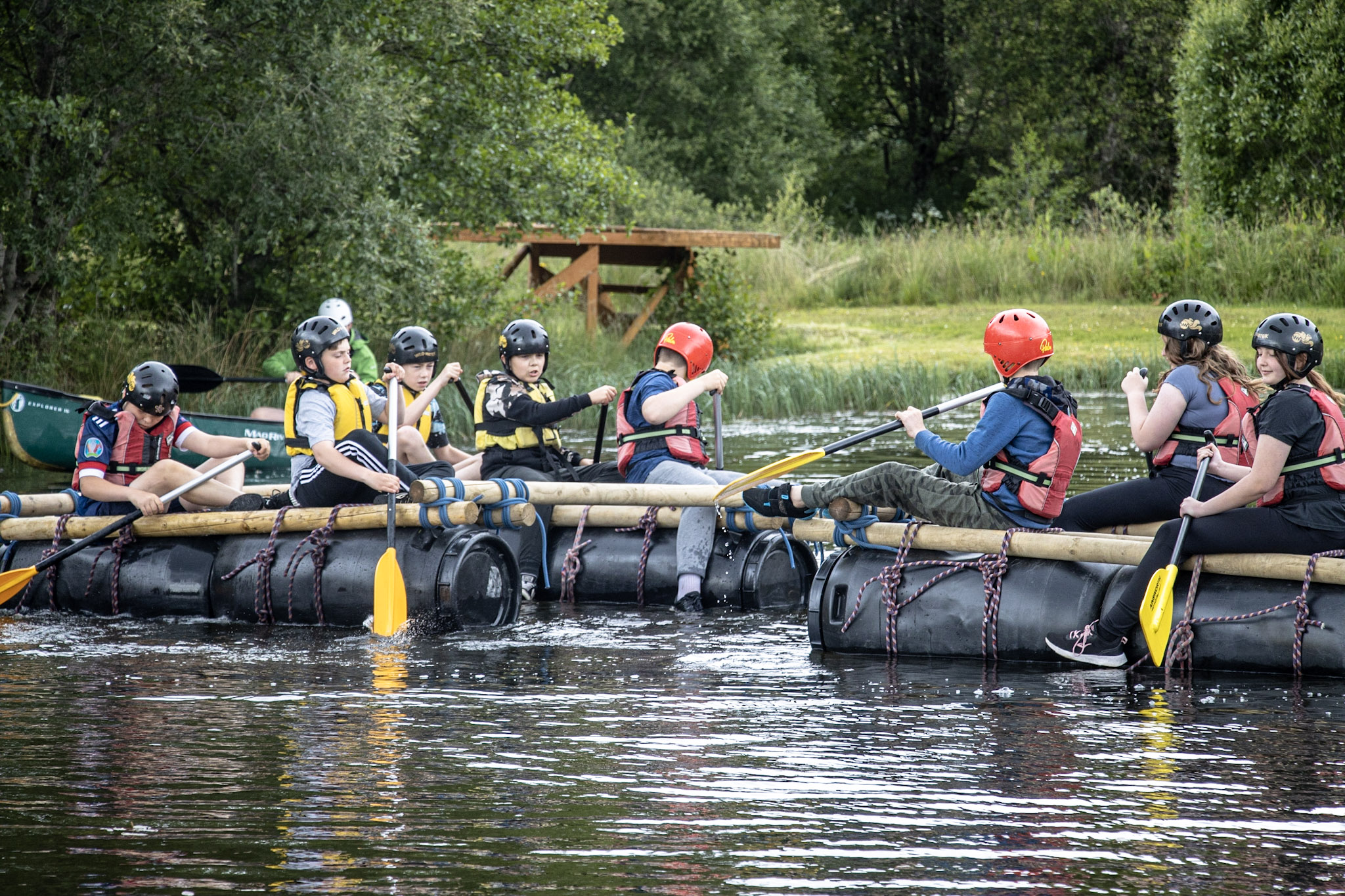 A group of students taking part in a raft building session with Cairngorms Activities