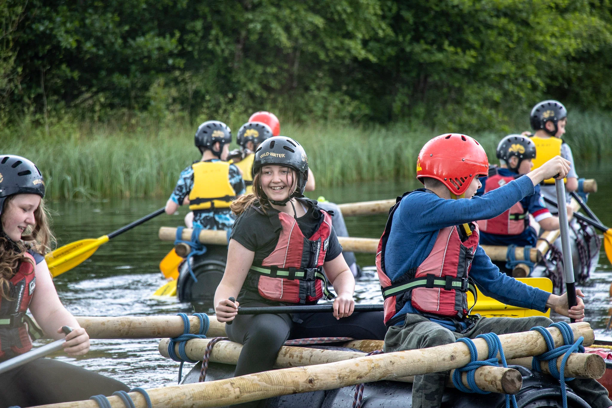 A group of young people taking part in raft building