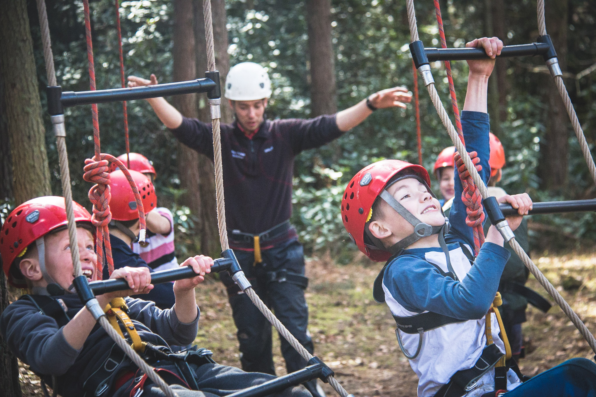 Two boys climbing the ropes during a high ropes party