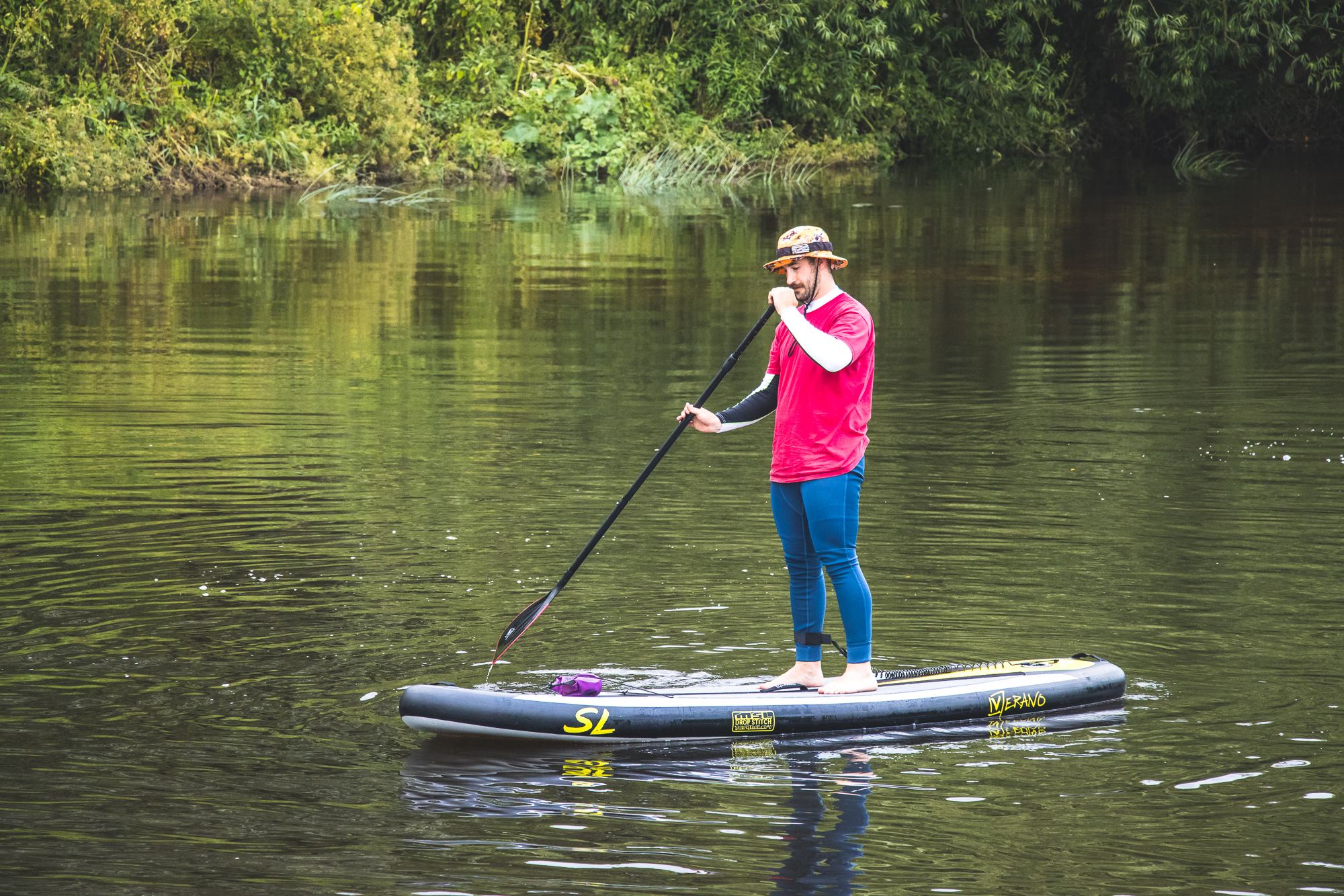 A man trying stand-up paddleboarding for the first time
