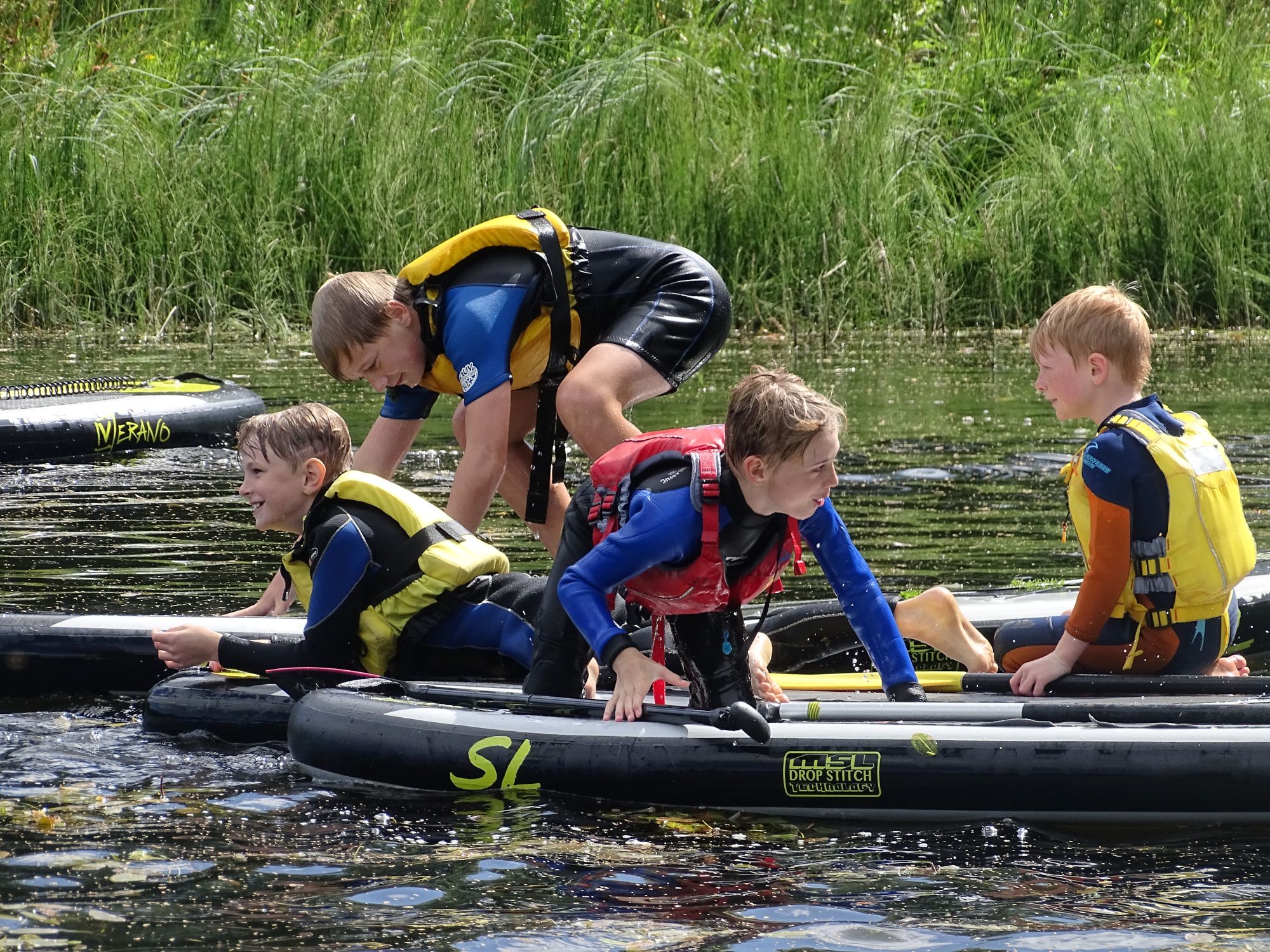A group of friends causing a splash during a paddling kids party