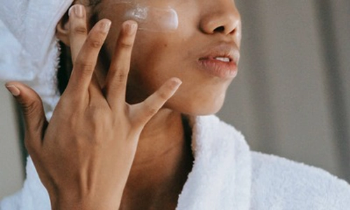 woman applying serum to face