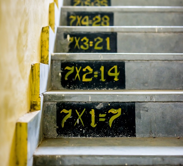 Stairs with times tables drawn on in chalk.