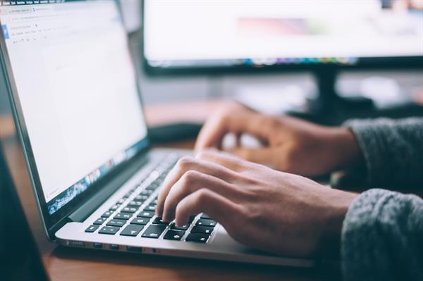 Person typing on a laptop social media marketing Person typing on a laptop social media marketing