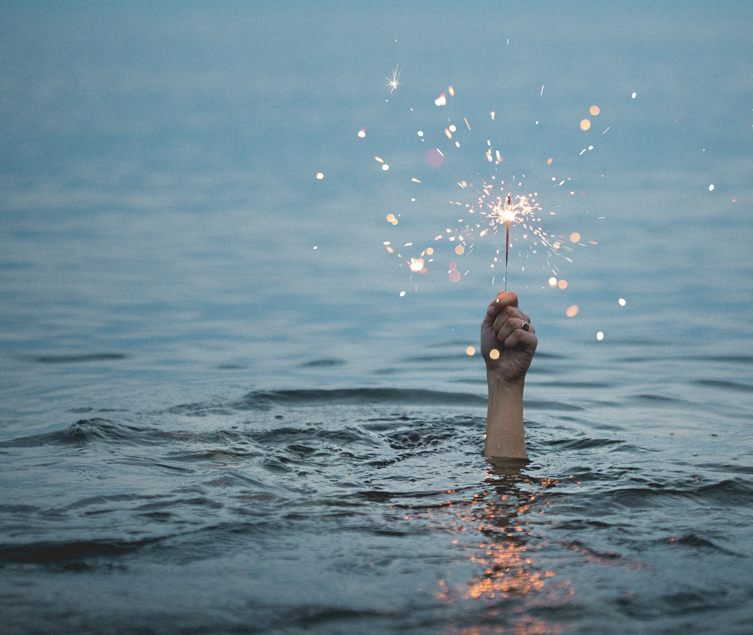 hand with sparkler in water