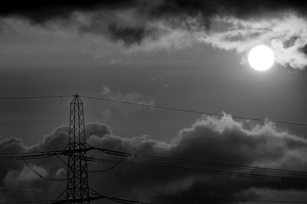Sun and electricity cables representing renewable energy
